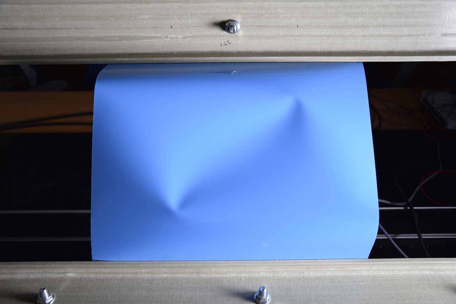 photo of bent blue sheet with two indentations